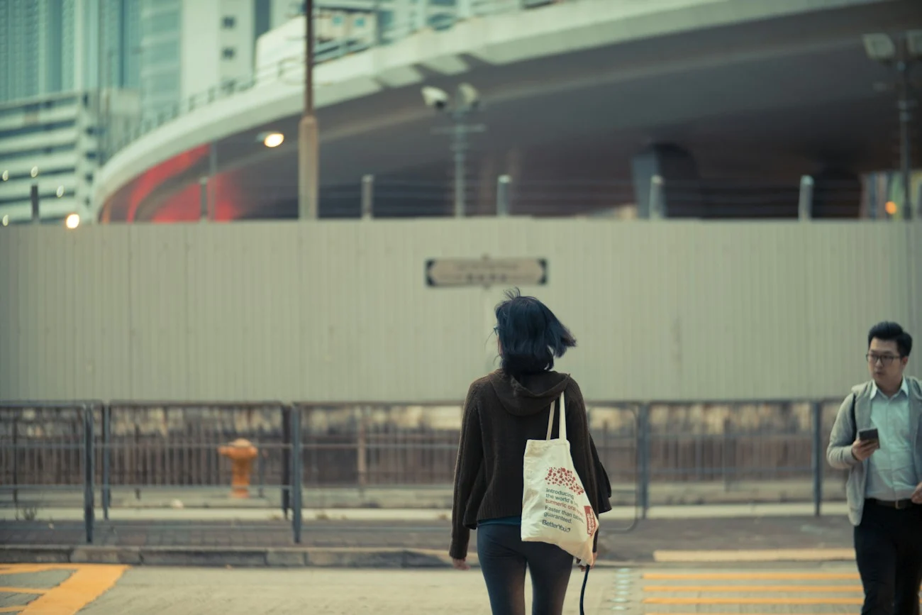 Woman carrying a printed canvas tote on a city street — lifestyle reference